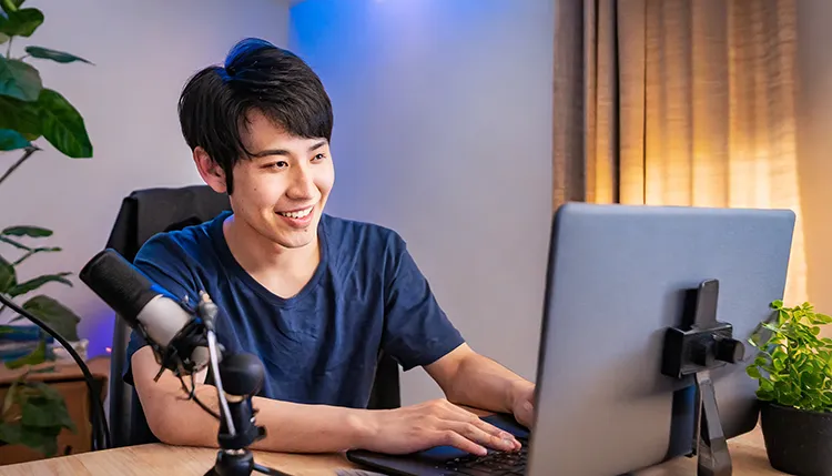 a youtuber in his room looking at his computer screen 